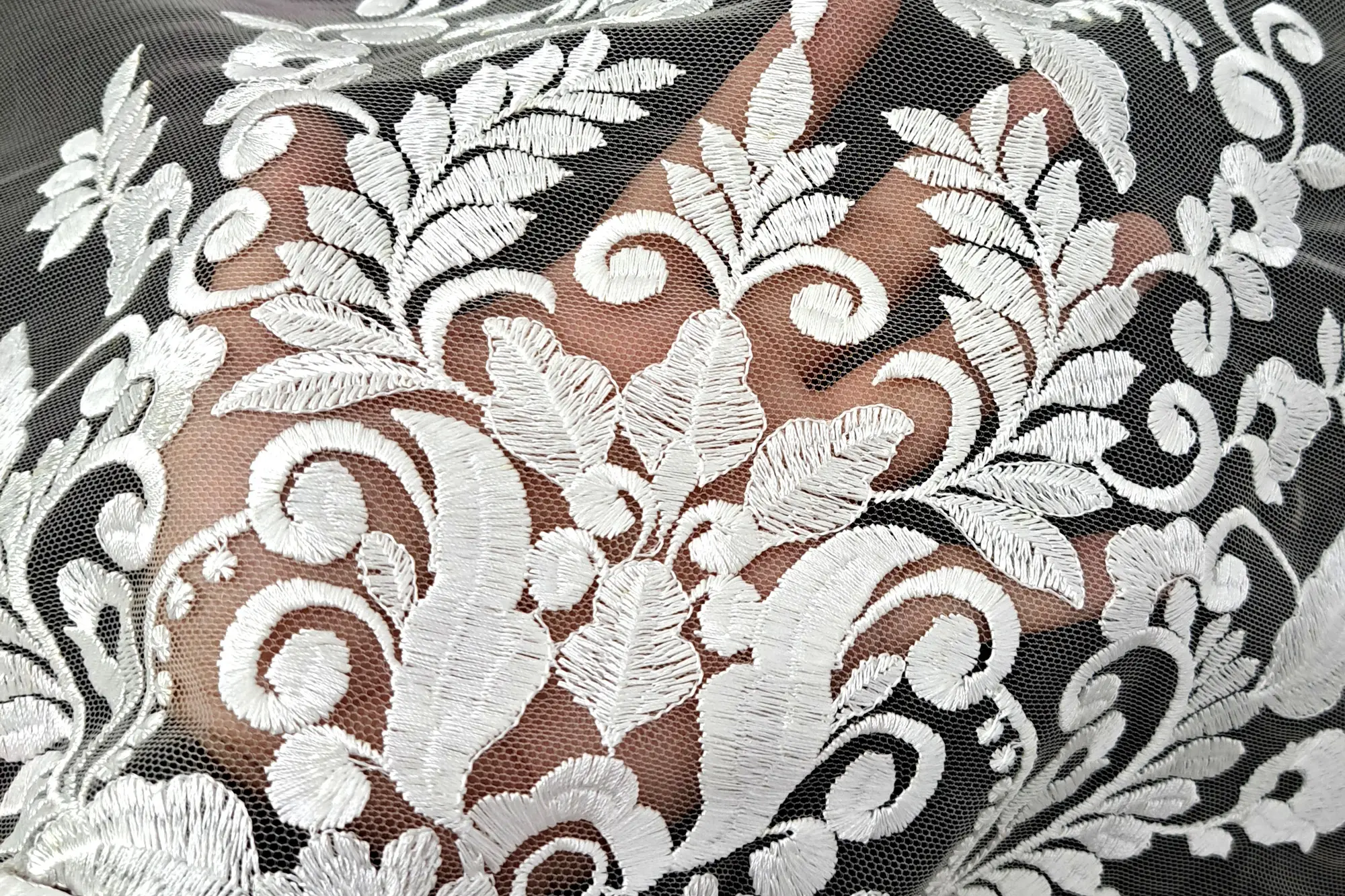 White embroidered brocade on tulle, photographed close