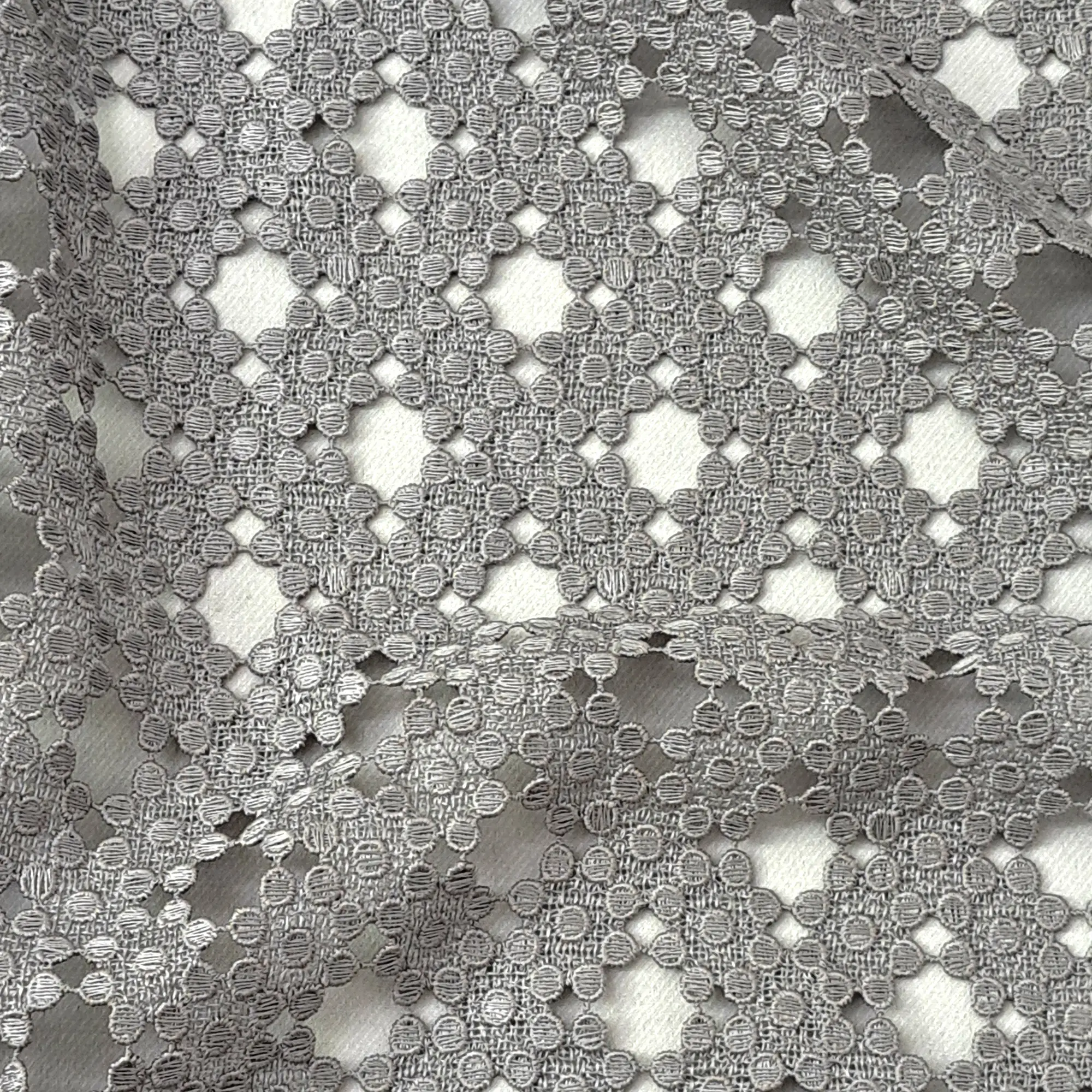 Guipure lace, photographed in detail. The ground cloth has been dissolved and the threads lock into one another.